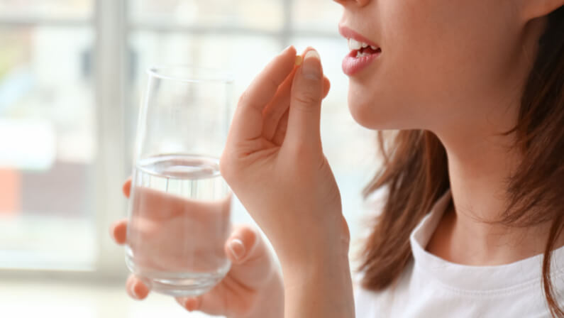lady taking medicine for her allergy